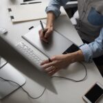 Male designer using graphics tablet while working with computer