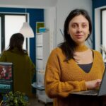 Woman looking at camera smiling working in creative media agency