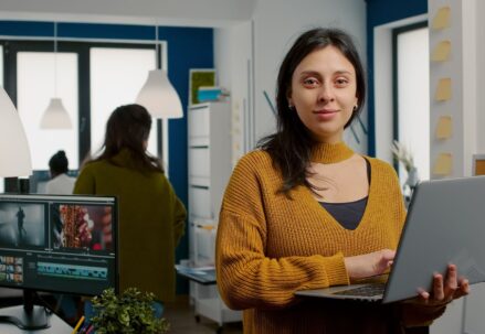 Woman looking at camera smiling working in creative media agency