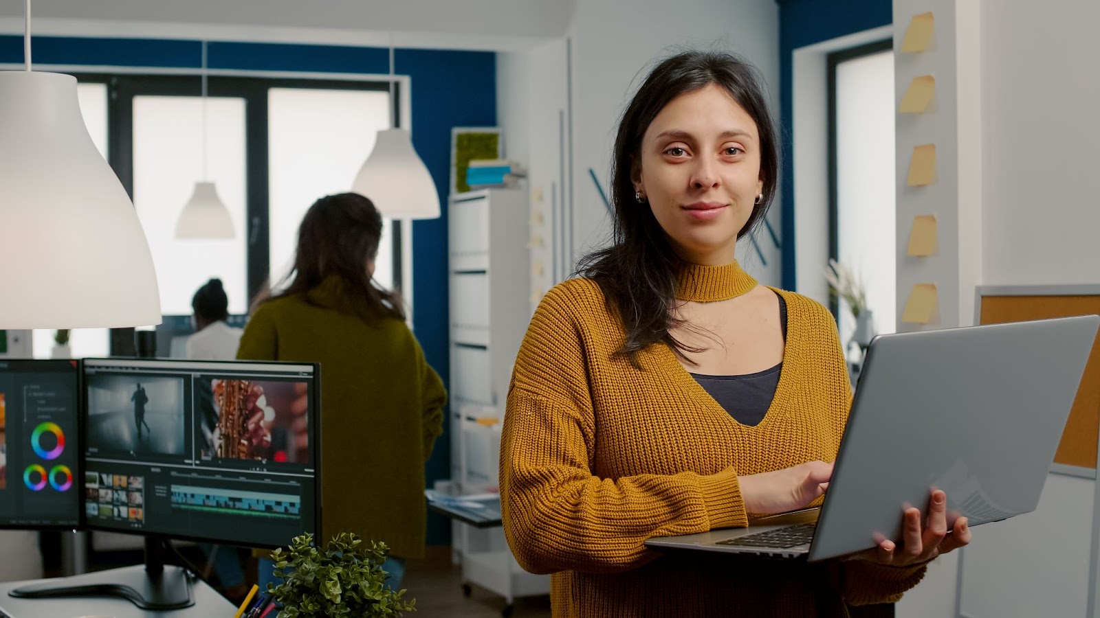 Woman looking at camera smiling working in creative media agency