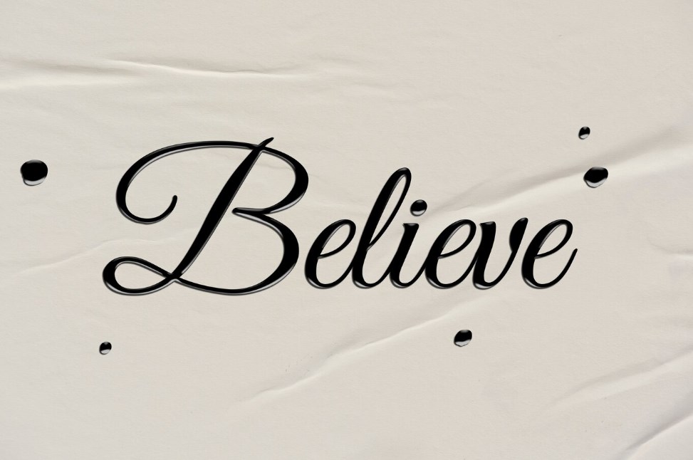 calligraphy letter writing: the word “Believe” written on paper