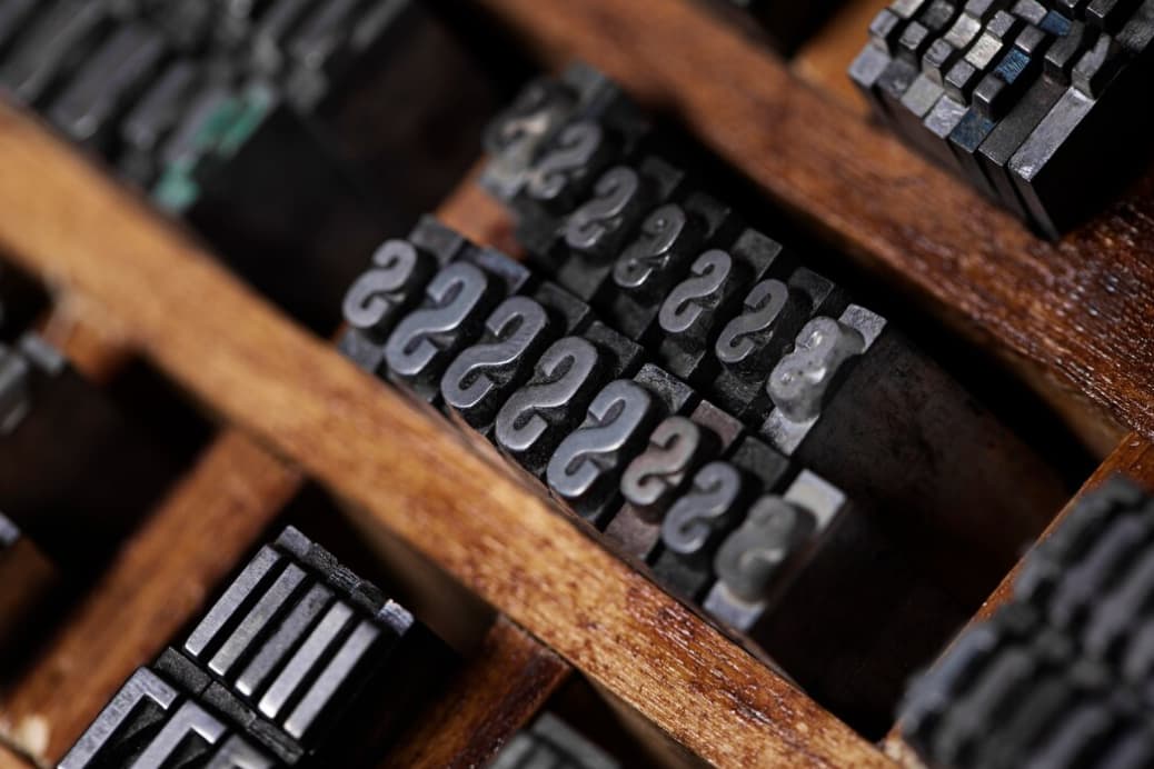 Rows of metal typeset letters in a printing tray