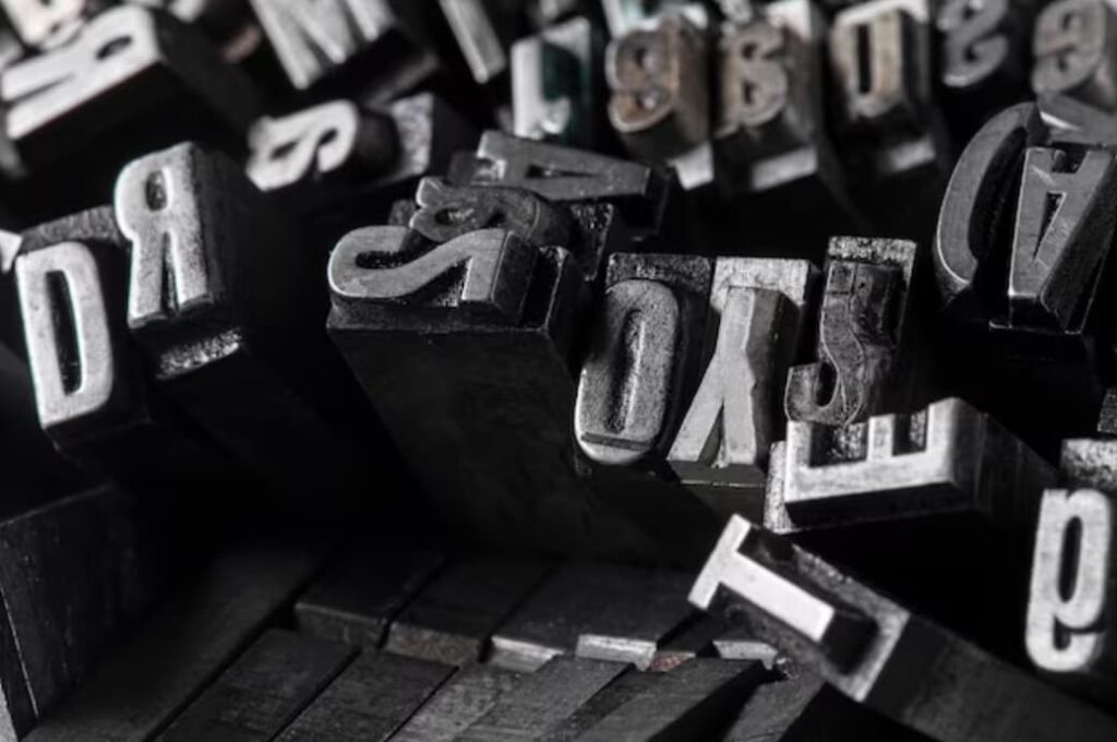 A close-up of assorted metal letterpress printing blocks