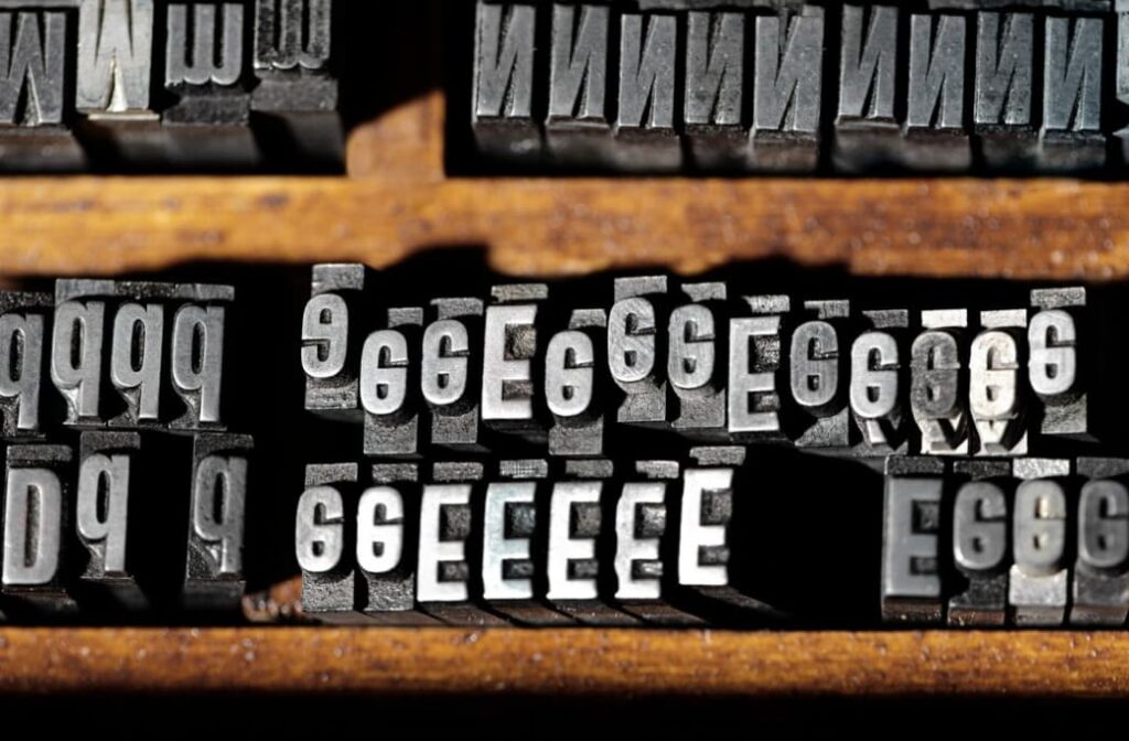 Close-up of metal typesetting blocks showing reversed numbers and letters