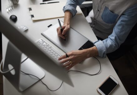 Male designer using graphics tablet while working with computer