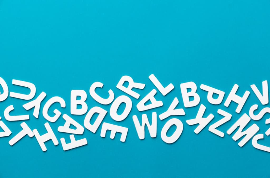 White alphabet letters scattered on a bright blue background