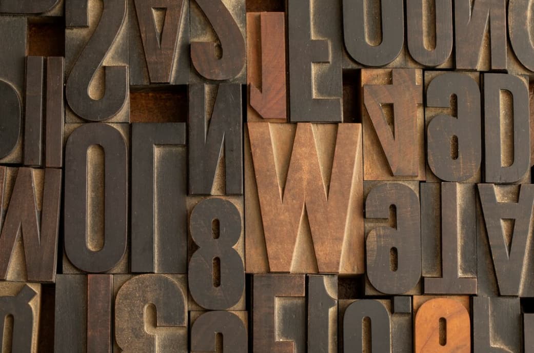 Various wooden letterpress blocks with letters and numbers in a close-up view